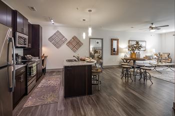 a kitchen and living room with a dining area and a table with chairs